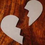 broken heart cardboard on brown wooden table top